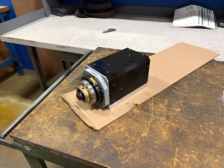 The completed prototype spindle on the bench in Grafton, Wisconsin. The black anodized aluminum housing carries integrated cast iron bearing carriers — light enough for a portable machine, durable enough for production life.